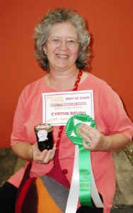 cynthe brush holding prize winning best of show honey rose petal jam and ribbons