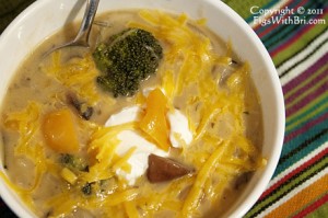 onion vegetable soup garnished with yogurt and grated cheddar cheese