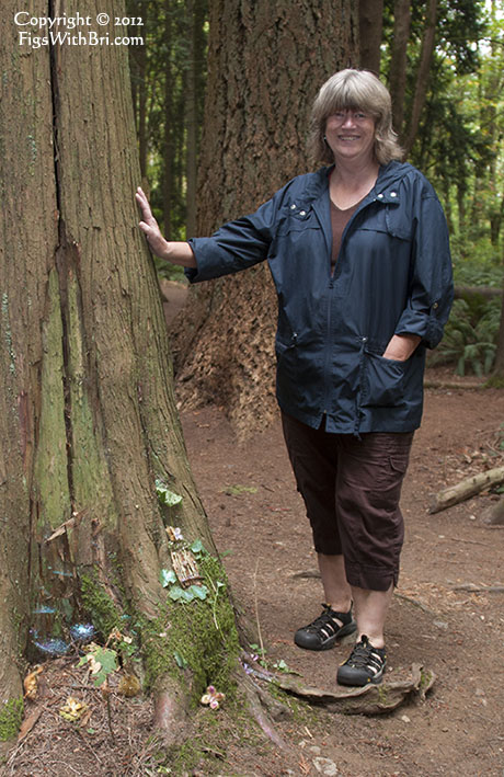 woman in forest next to a fairy house