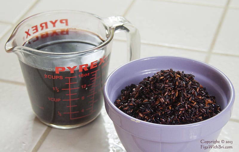 black rice in bowl with soaking water in pyrex cup